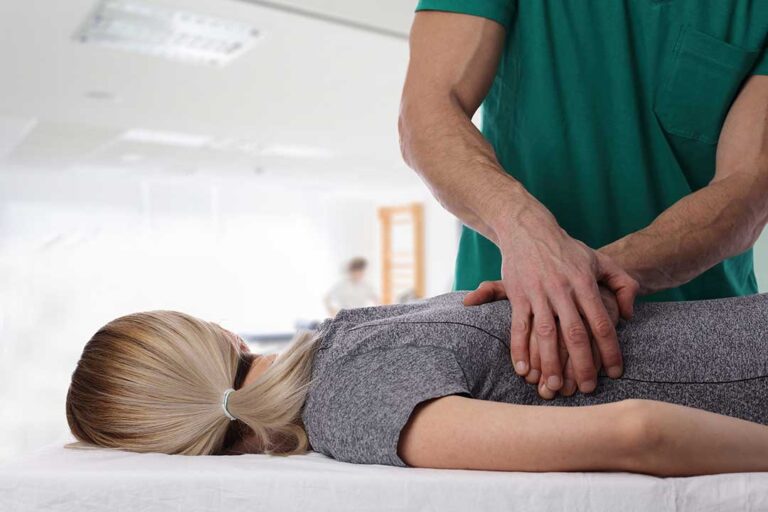 A chiropractor demonstrating gentle adjustment techniques on a smiling young child with a parent nearby.